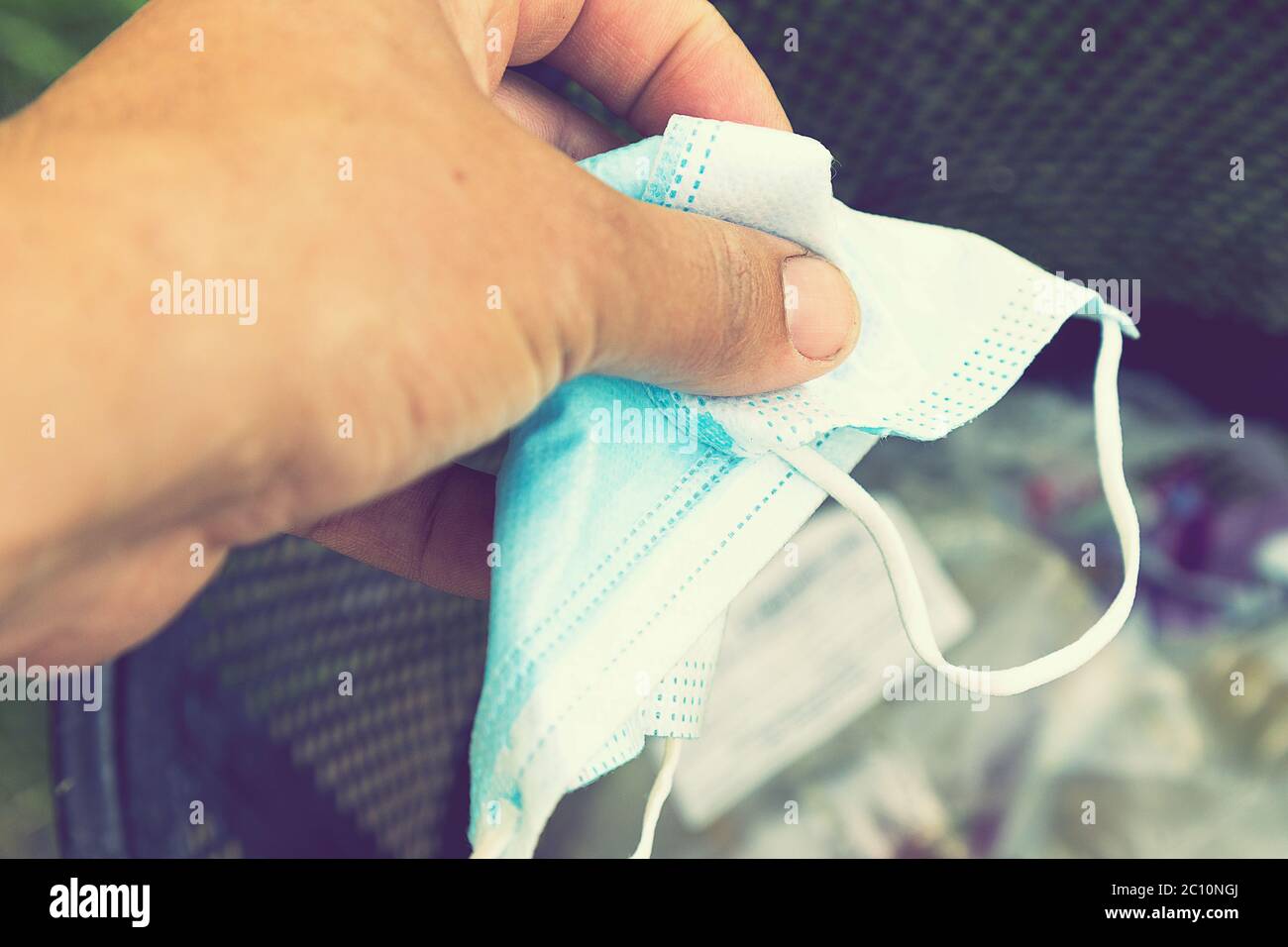 Man throwing face masks into trash in park. Man throwing used surgical