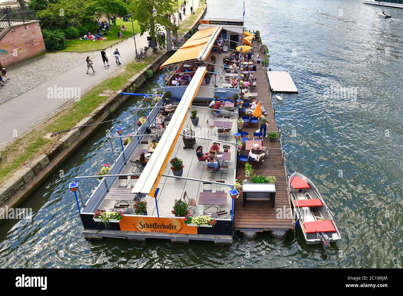 Frankfurt am Main, Germany - June 2020: Restaurant with tourists on a boat called 'Bootshaus' on Main river in Frankfurt Stock Photo