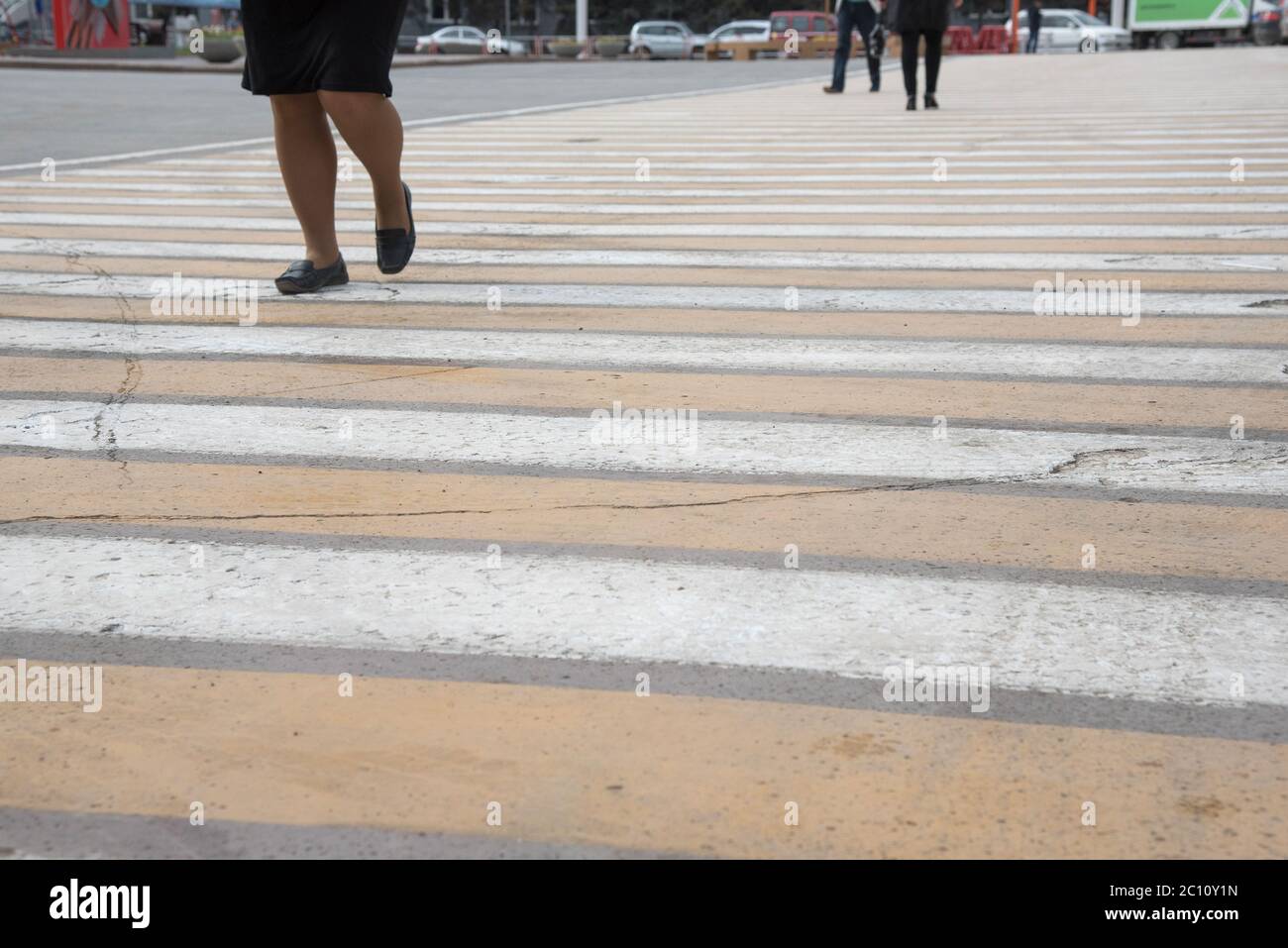 Pedestrian crossing on asphalt with yellow and white stripes and people ...