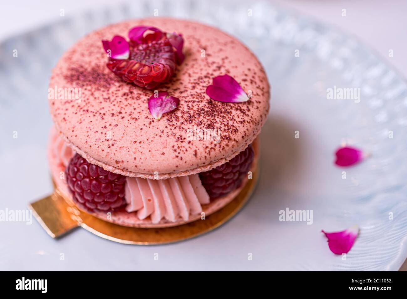 Beautiful Pink Raspberry Macaron cookies on blue plate. Healthy food. Blue table background. Top view.  Stock Photo
