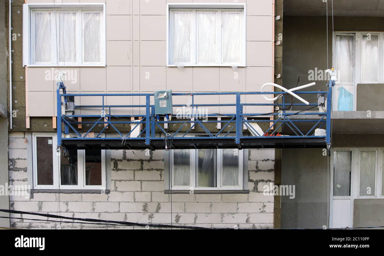 construction suspended cradle without workers on a newly built high-rise building Stock Photo
