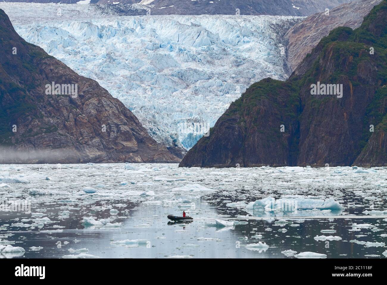 Man in Boat in Front of Sawyer Glacier at Tracy Arms Fjords in Alaska United States. Stock Photo