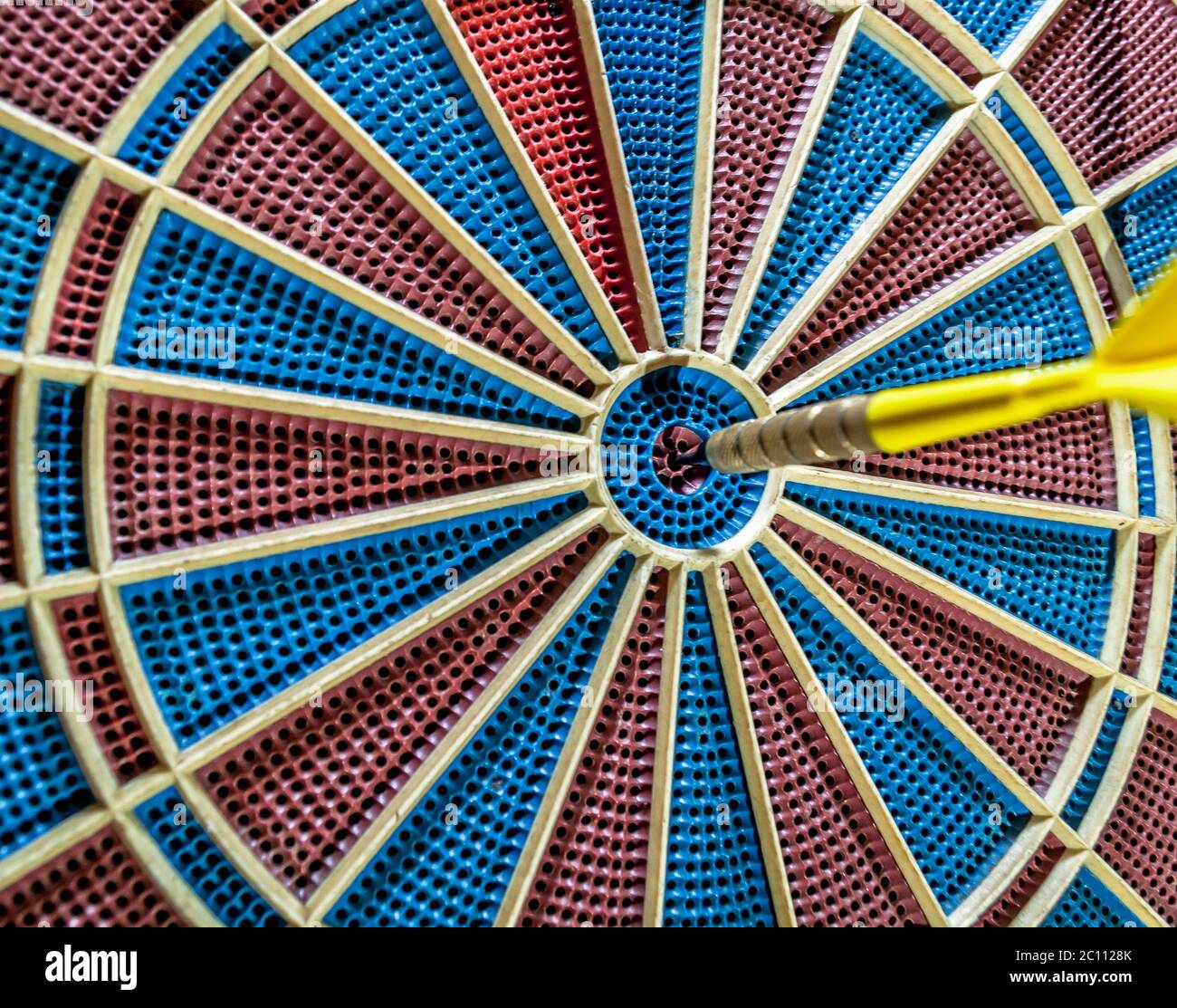 Dart in bulls eye of blurred dartboard Stock Photo