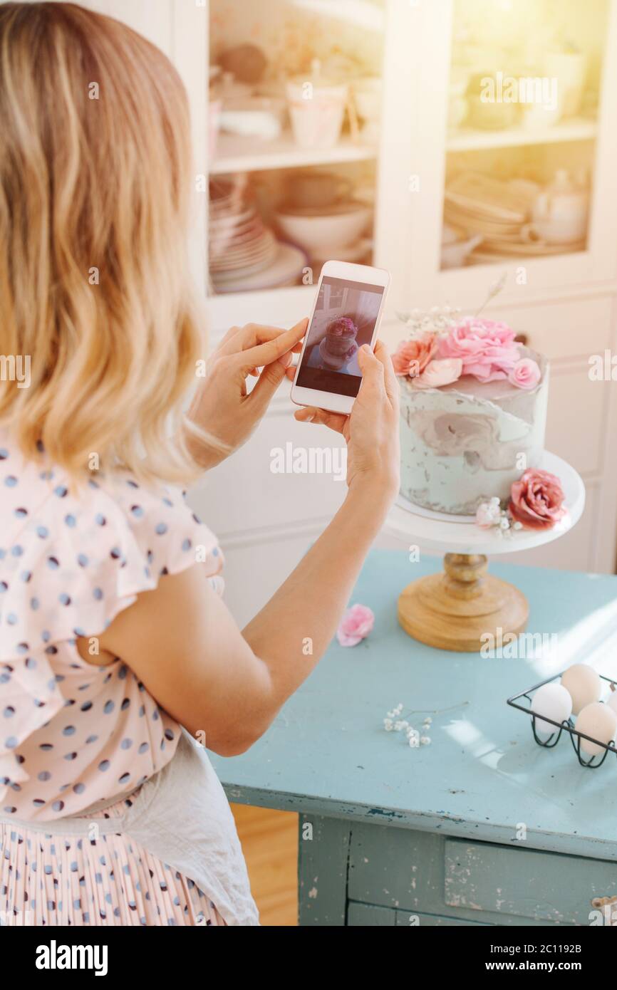 Housewife texing, taking picture of sweet cake she baked. Stock Photo