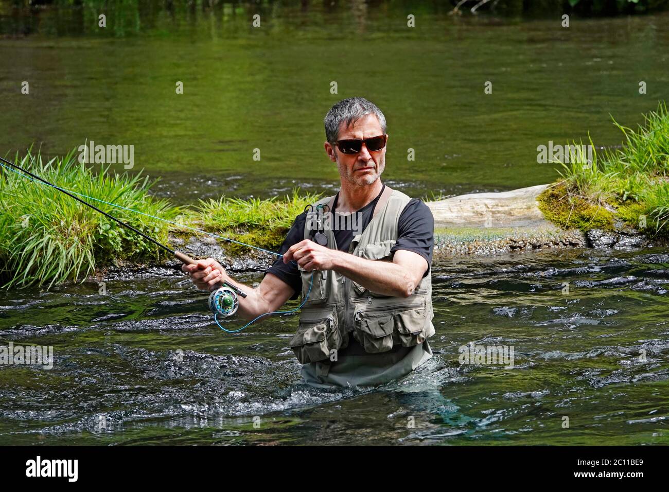A trout fisherman fly fishing for rainbow trout with a fly rod on the