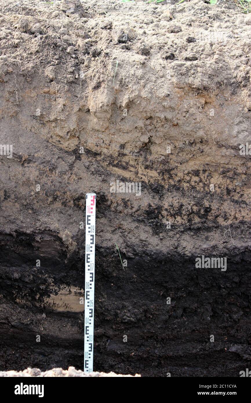 the trench depth and the earth layers, visible under peat extraction in preparation for the construction of the road, more meter Stock Photo