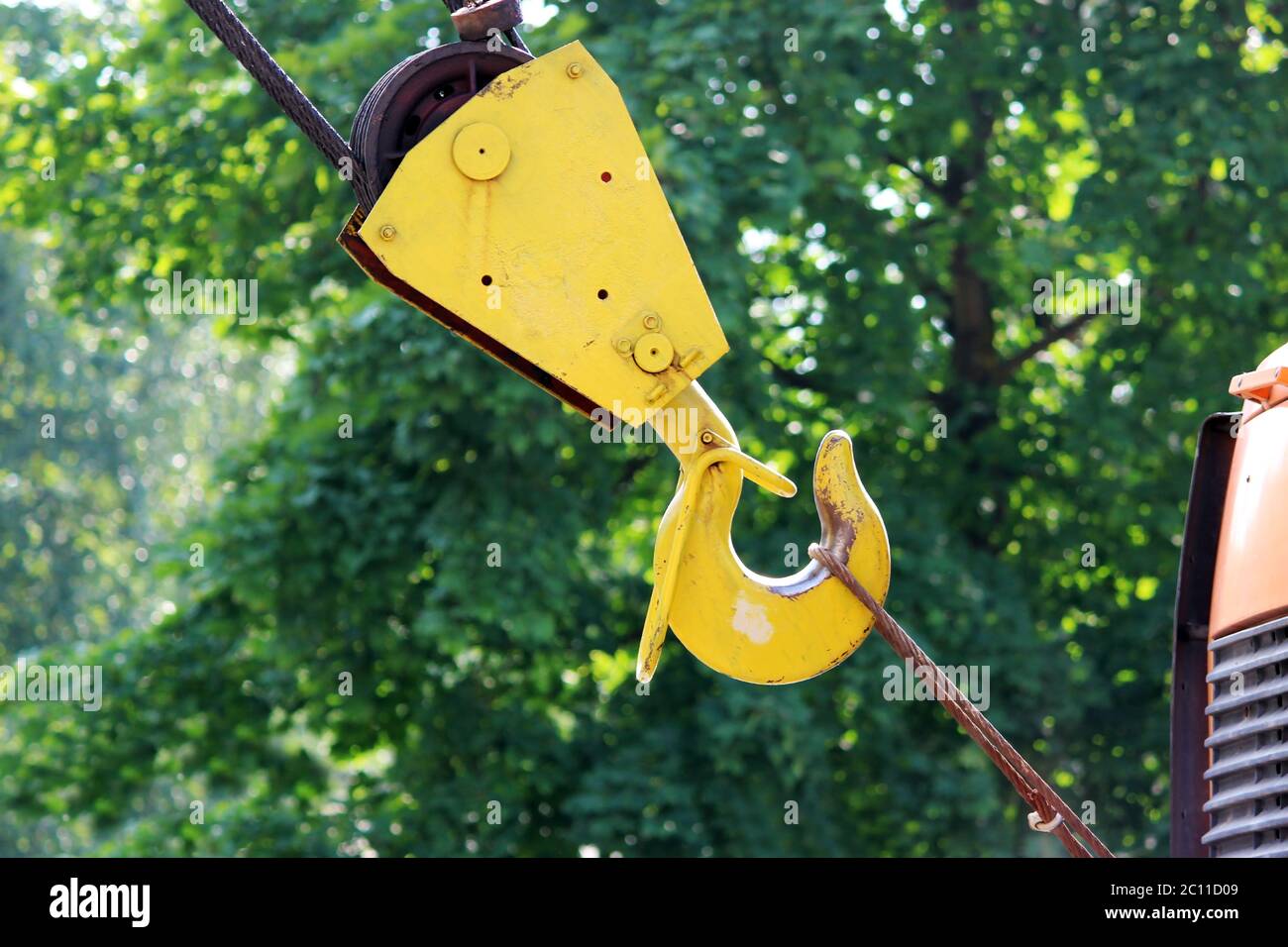 yellow crane hook of the car on a background  green. Stock Photo