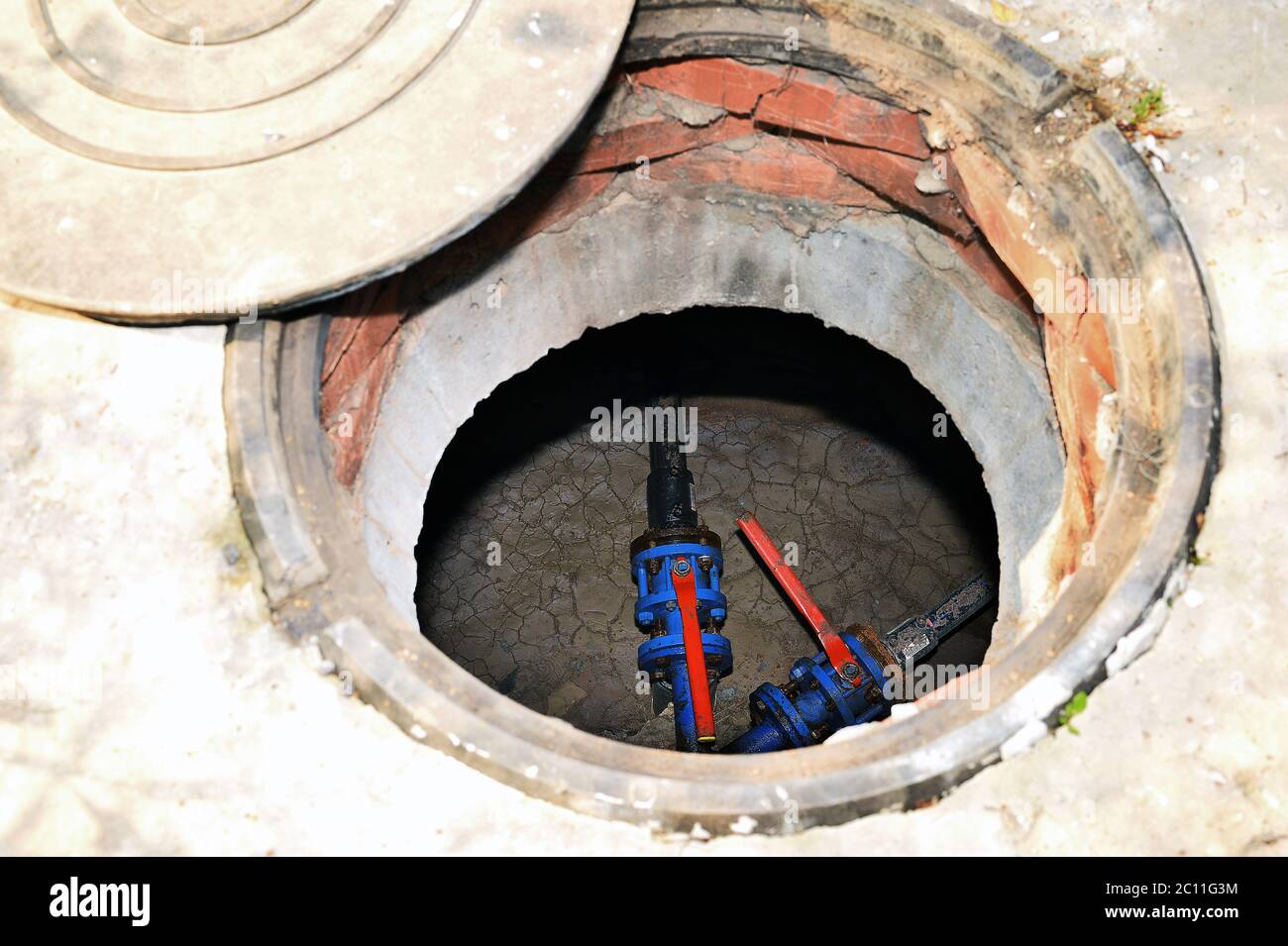 Concrete cesspit with an open hatch on the ground in the summer Stock Photo