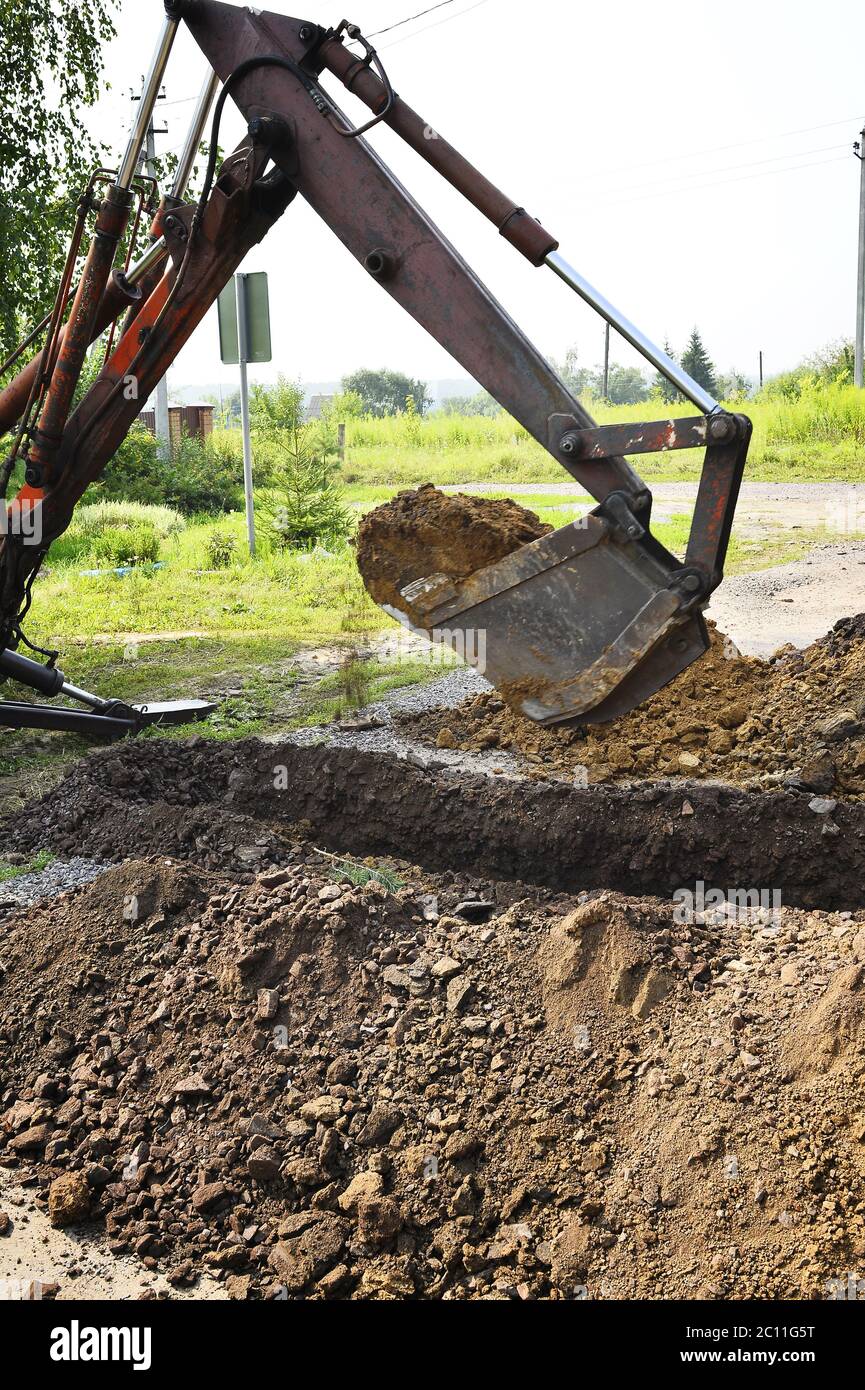 Excavator bucket digging a trench in the dirt ground Excavator bucket
