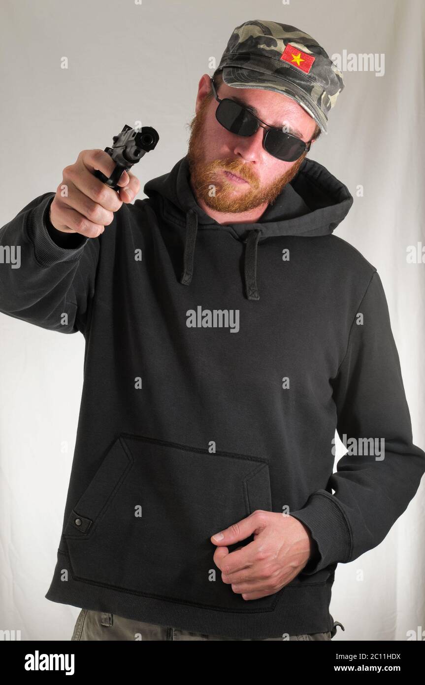 Black Dressed Young Man Holding a Pistol Gun Stock Photo - Alamy