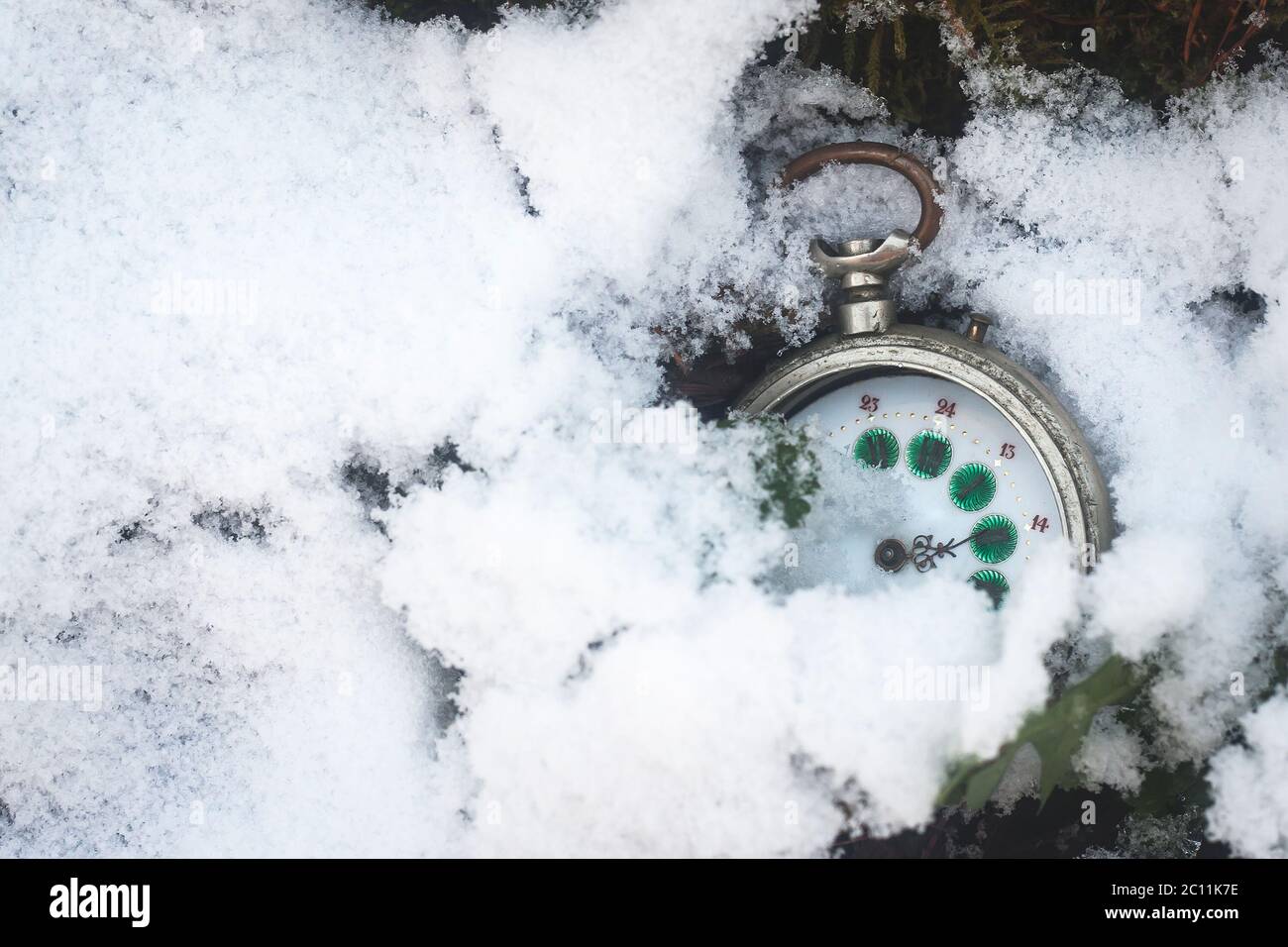 old pocket watch burried in the snow Stock Photo