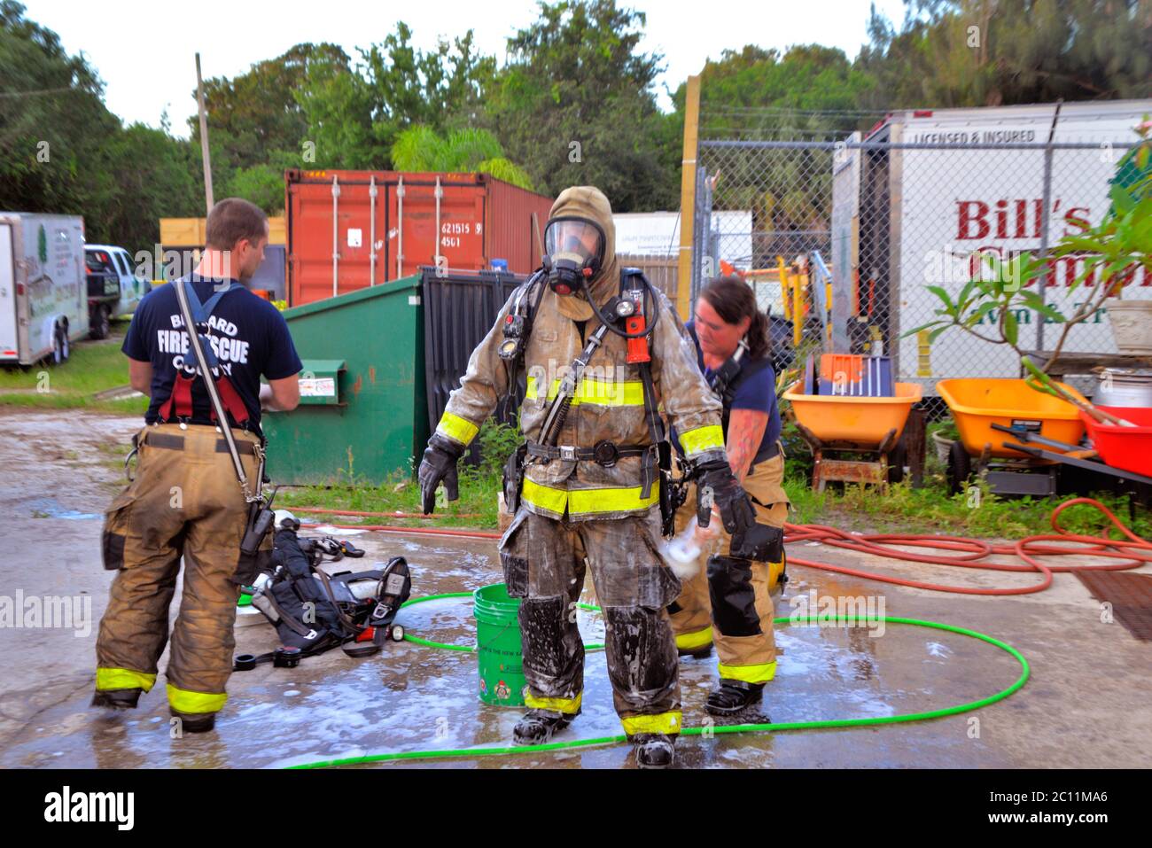 West Melbourne, Florida, USA. June 13, 2020. Early morning fire of suspicious origin sends one person to an Orlando burn unit. The fire in an automotive repair shop was contained by the Brevard County Fire Rescue crew to a single unit as the building had firewalls between units. Decontamination rules require the fireman to have their bunker gear washed with soap and water at the fire scene. Photo Credit: Julian Leek/Alamy Live News Stock Photo