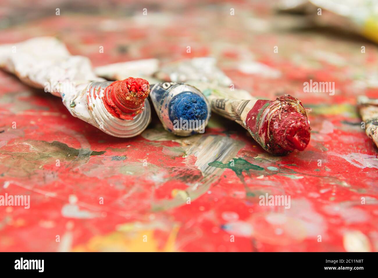 Old oil painting tubes on red splattered table Stock Photo Alamy