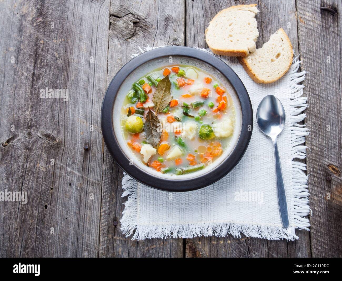 Fresh and tasty vegetable soup in plate on old wooden table Stock Photo ...