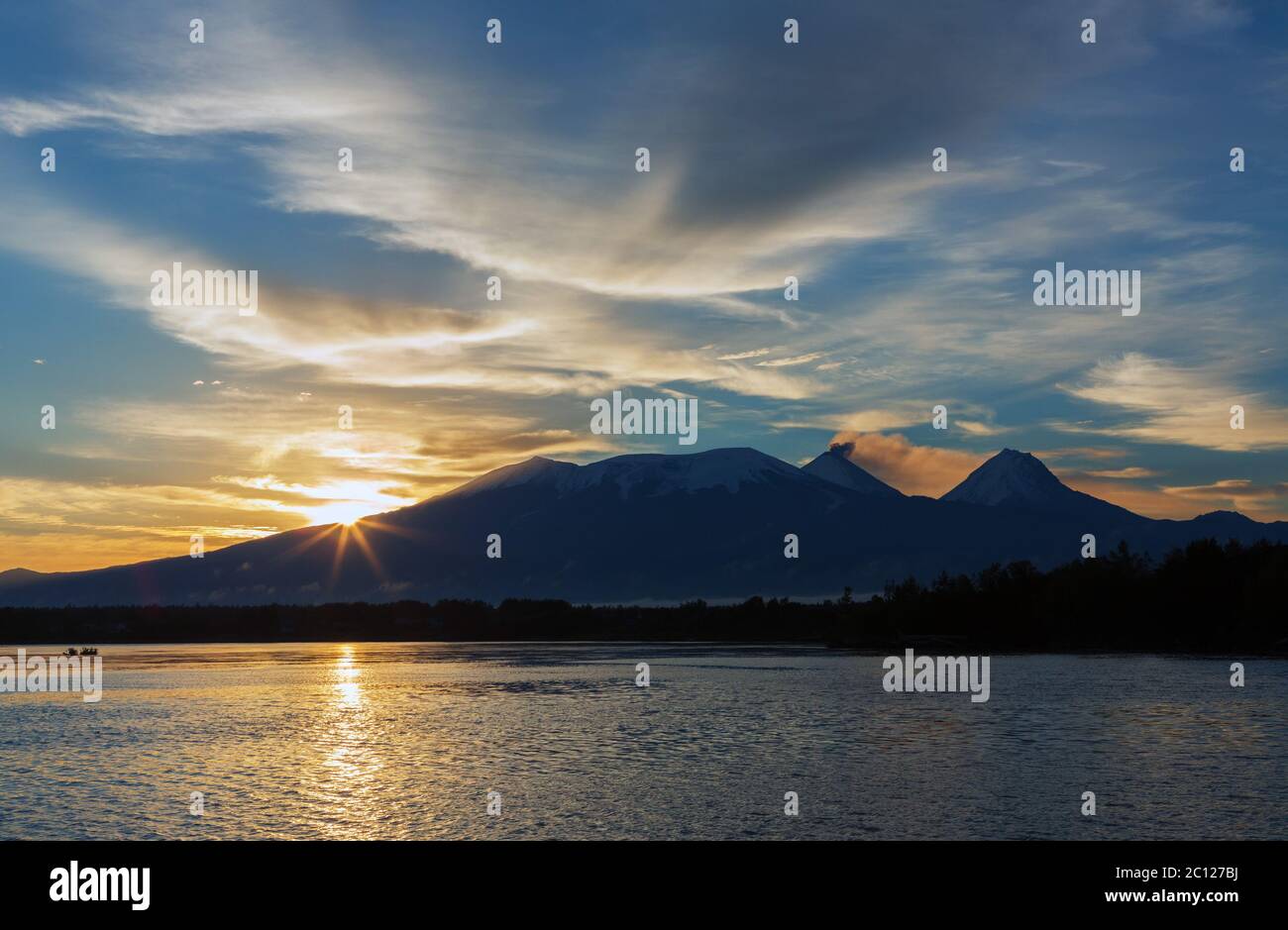Beautiful sunrise over volcanoes Kluchevskaya group with reflection in the river Kamchatka. Stock Photo