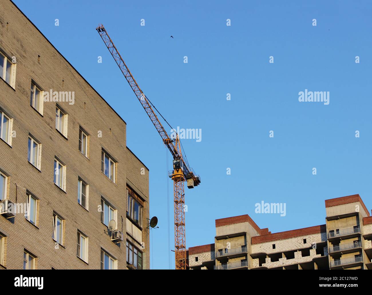 crane and newly built house with windows. wall structure  insulated non-combustible material basalt fiber tiled Stock Photo
