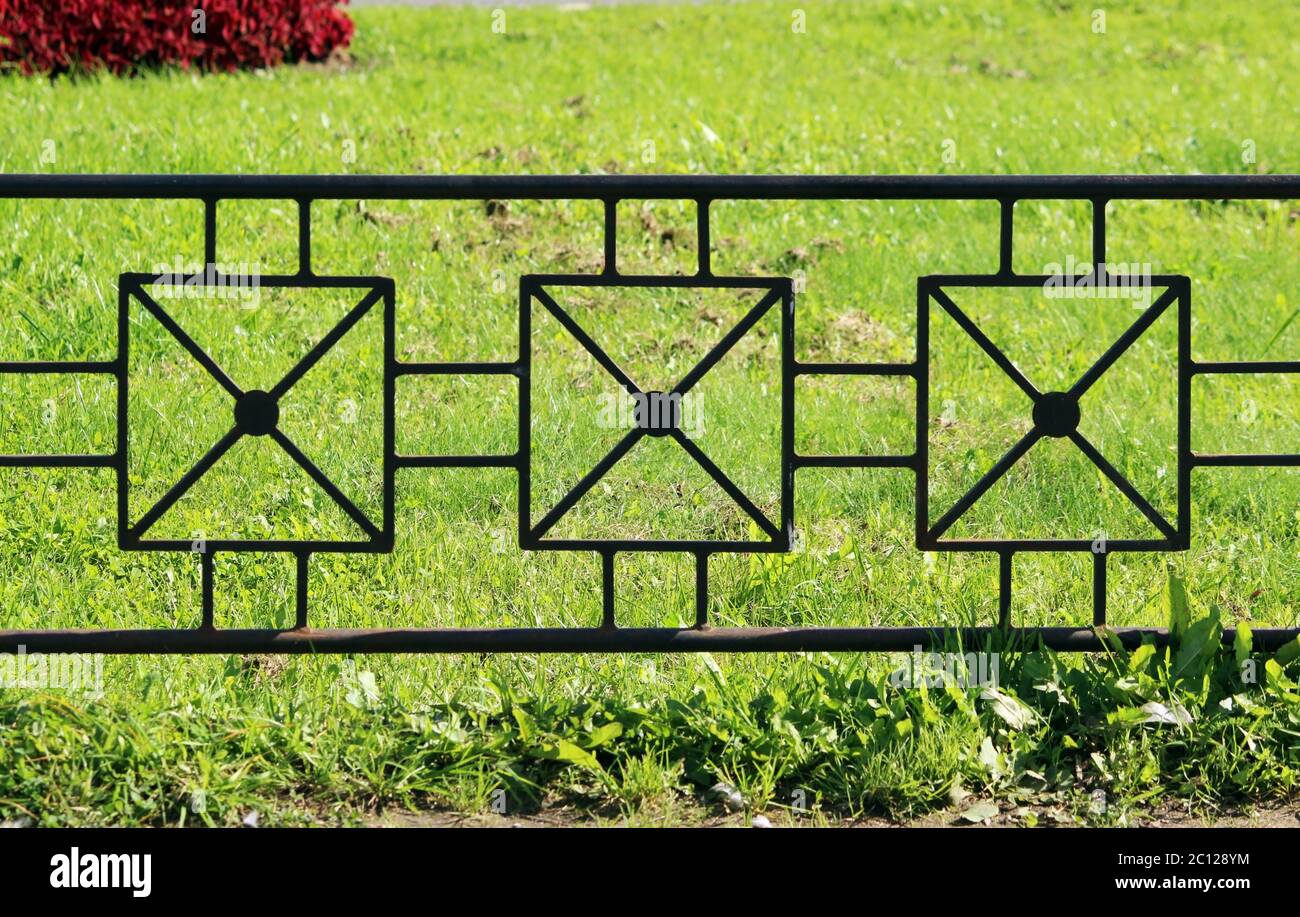 gray metal fence in the long run as a background and green grass Stock ...