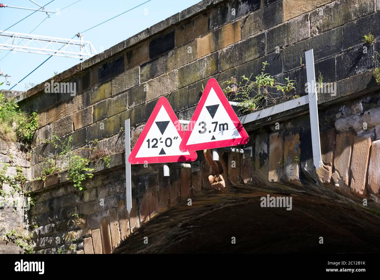 Bridge height restriction sign under railway train track Stock Photo