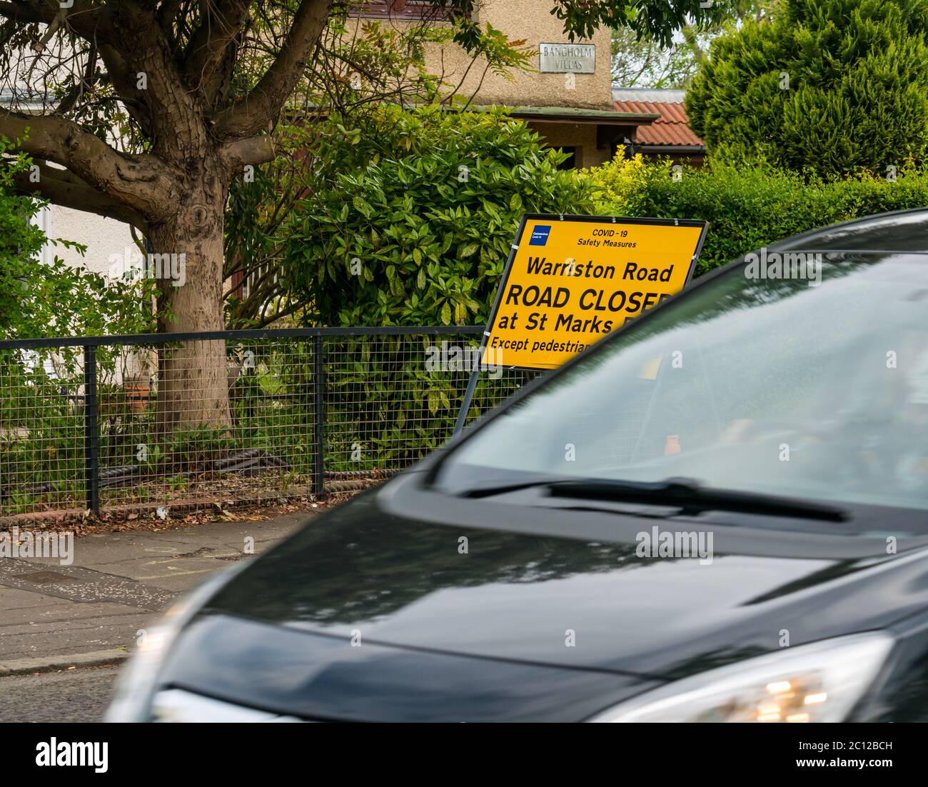 Blurred car driving past Covid-19 pandemic road closure sign, Ferry Road, Edinburgh, Scotland, UK Stock Photo