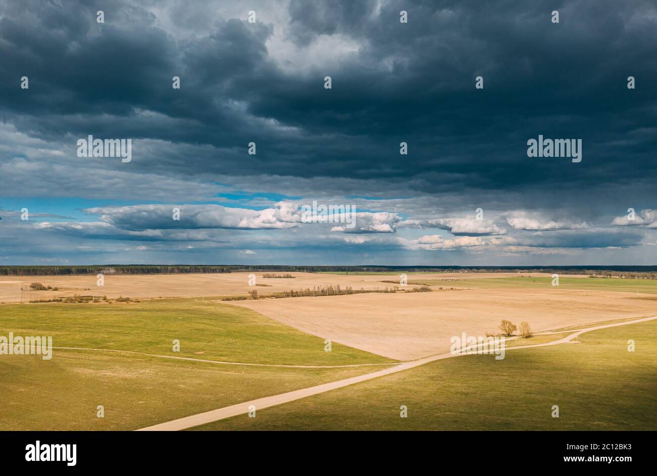 Aerial View. Amazing Natural Dramatic Sky With Rain Clouds Above Countryside Rural Field Landscape In Spring Day. Scenic Sky With Fluffy Clouds On Stock Photo