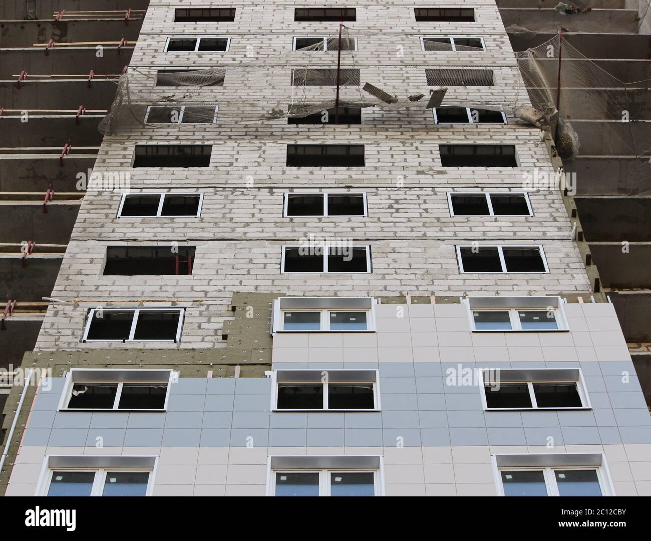 Protective catching grid net belay guard tense in the construction of a multistory newly building house. Stock Photo