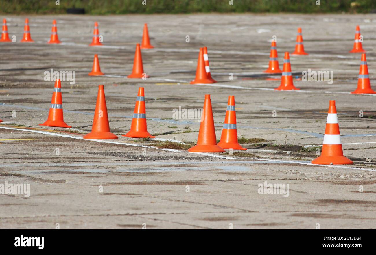 plastic signaling traffic cones are standing on the site where the drivers pass the exam  the right trucks driving. Stock Photo