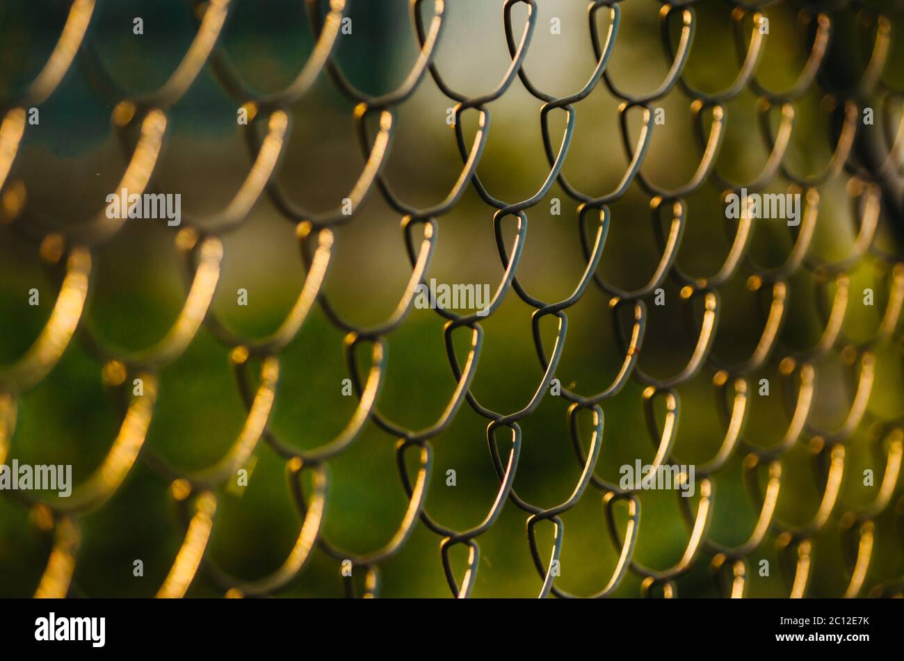 Golden hour metal wire fence pattern Stock Photo