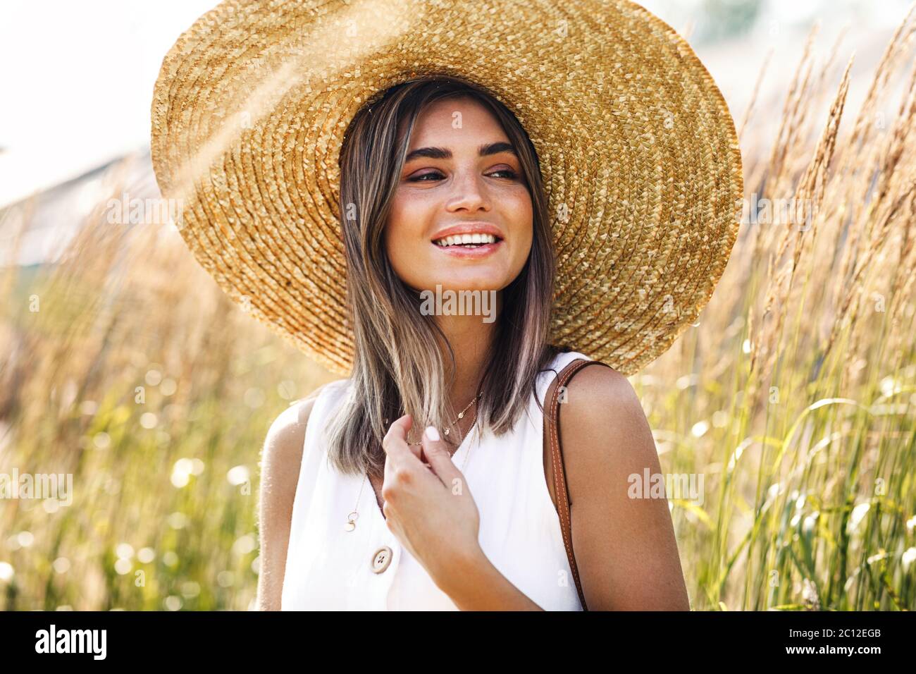 Woman wearing straw hat standing hi-res stock photography and images ...