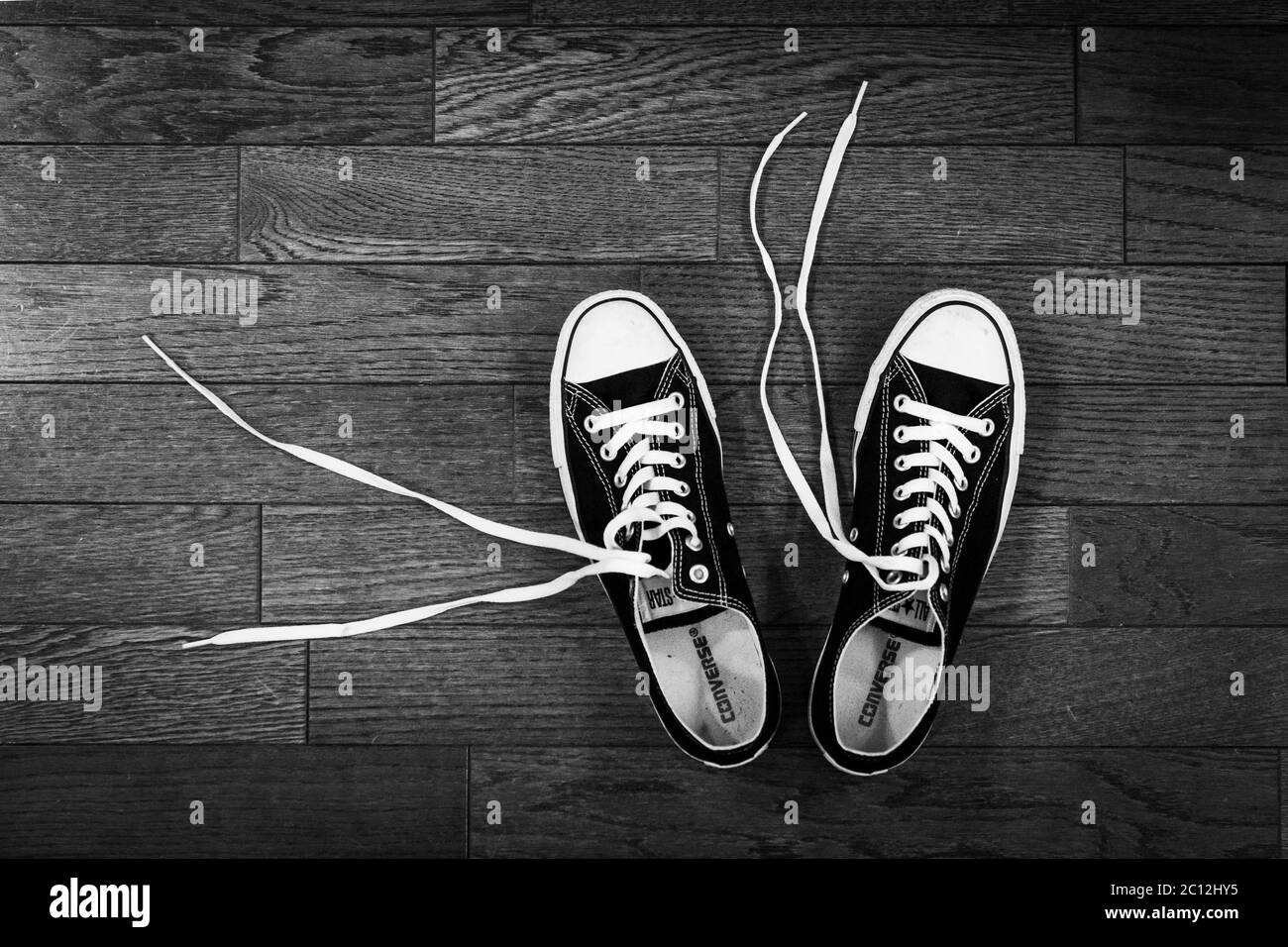 black and white converse cons sneakers on a wood floor Stock Photo