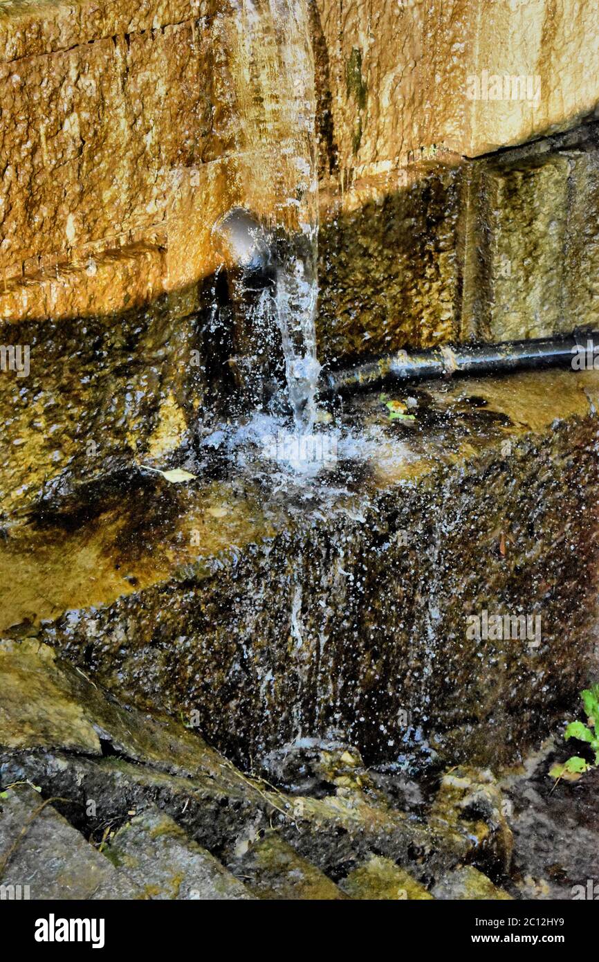 Water flows along a dirty wall Stock Photo