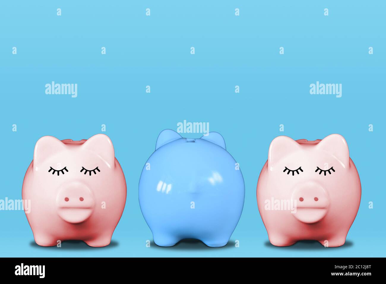 Stand out from the crowd or odd one out concept with piggy banks in a row with middle one in blue and turning its back. Concept includes discriminatio Stock Photo