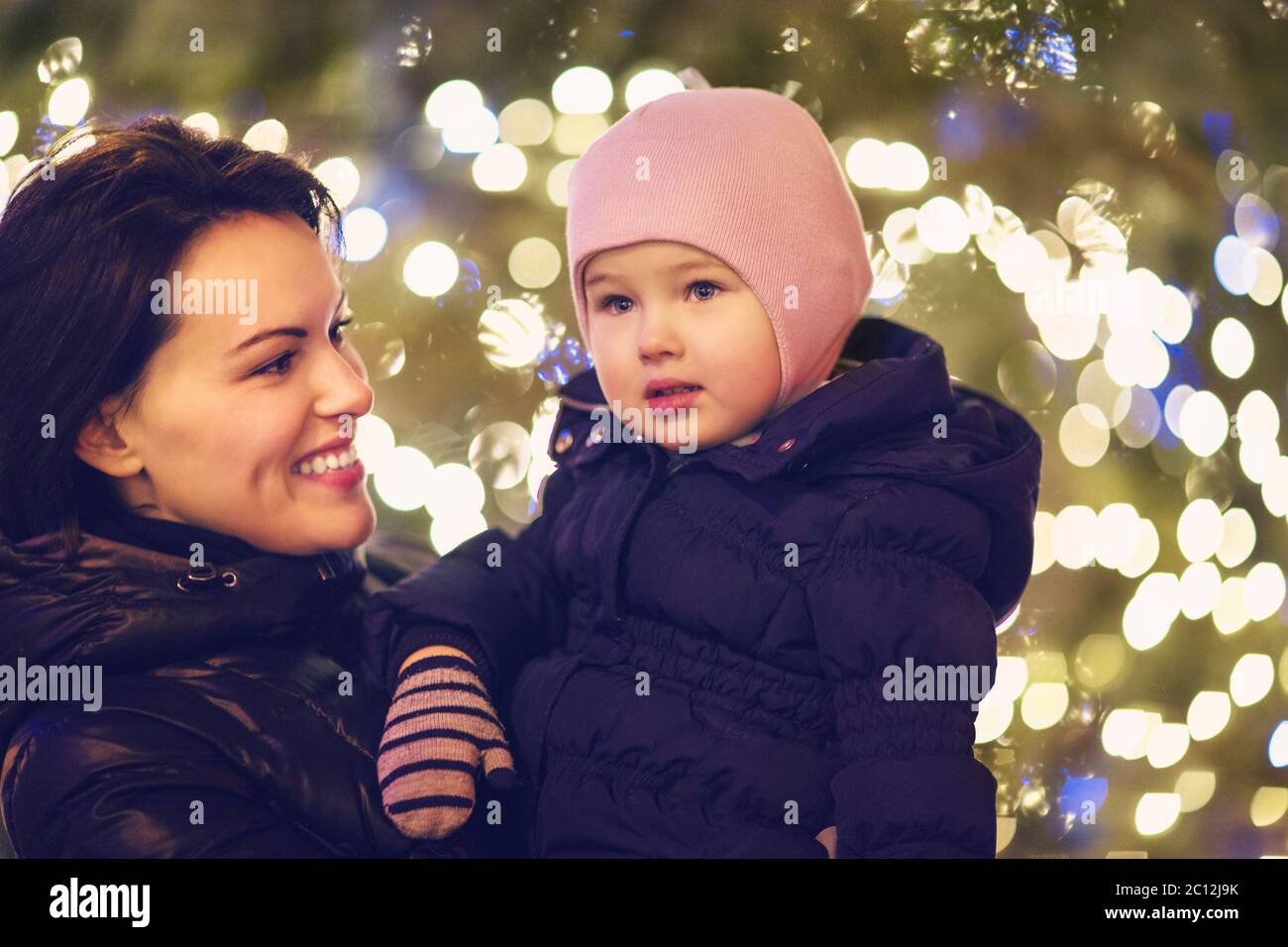 Mother and little daughter over Christmas background Stock Photo