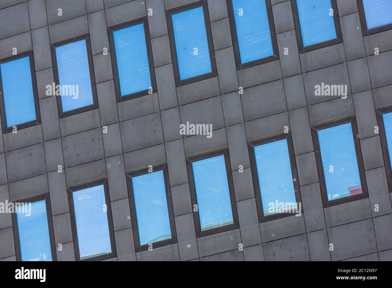 Windows of a tall grey building reflecting the blue sky Stock Photo - Alamy