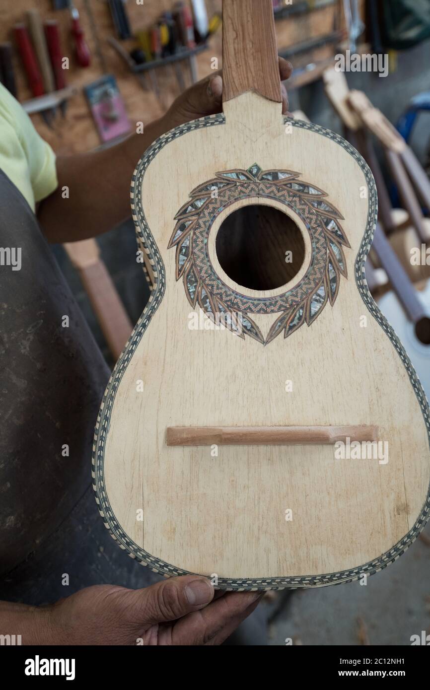 Luthier Panfilo Enriquez holds a custom guitar in his workshop in Paracho, Michoacan, Mexico. Stock Photo