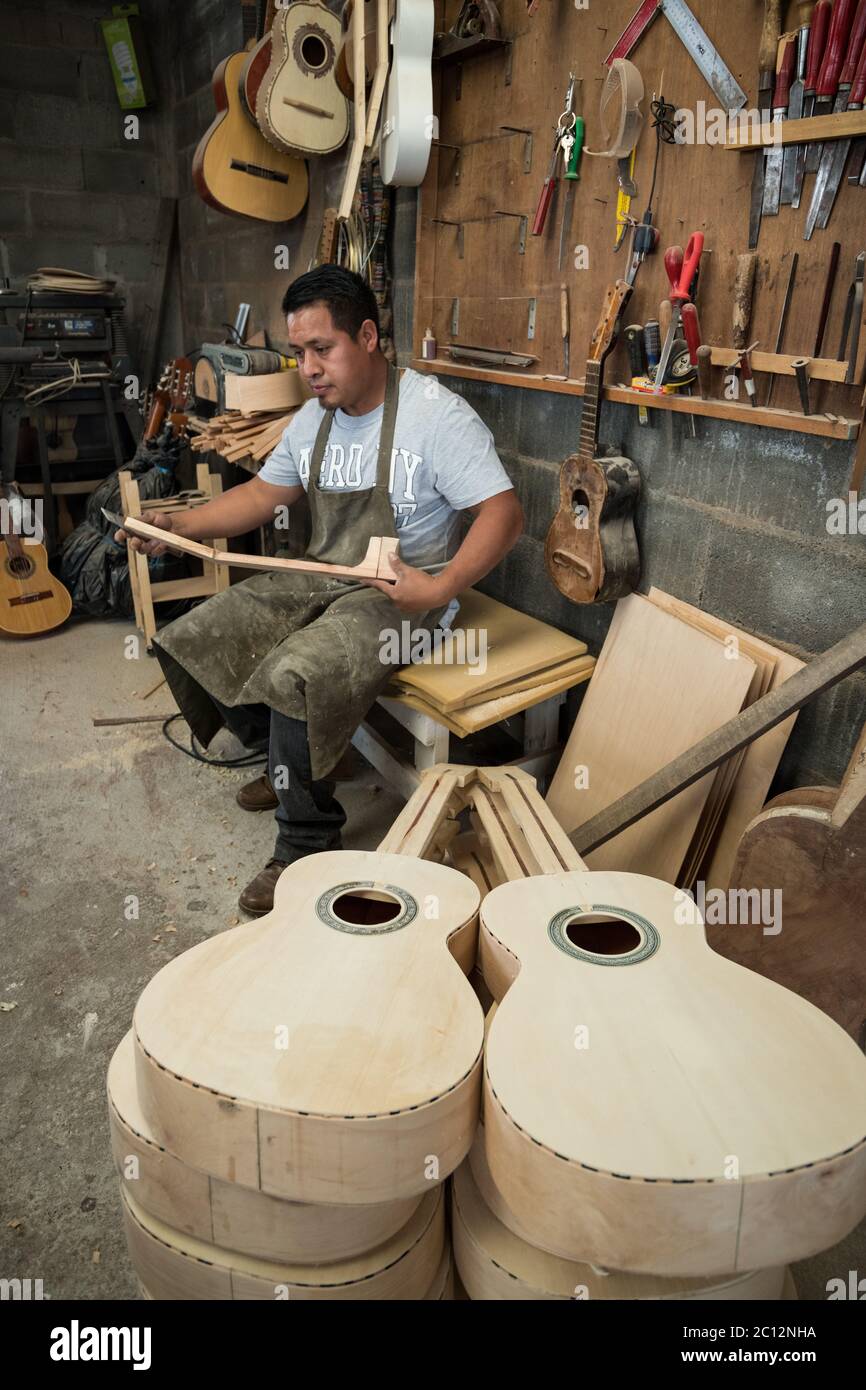 Luthier Claudio Enriquez works on a custom guitar in his workshop in Paracho, Michoacan, Mexico. Stock Photo