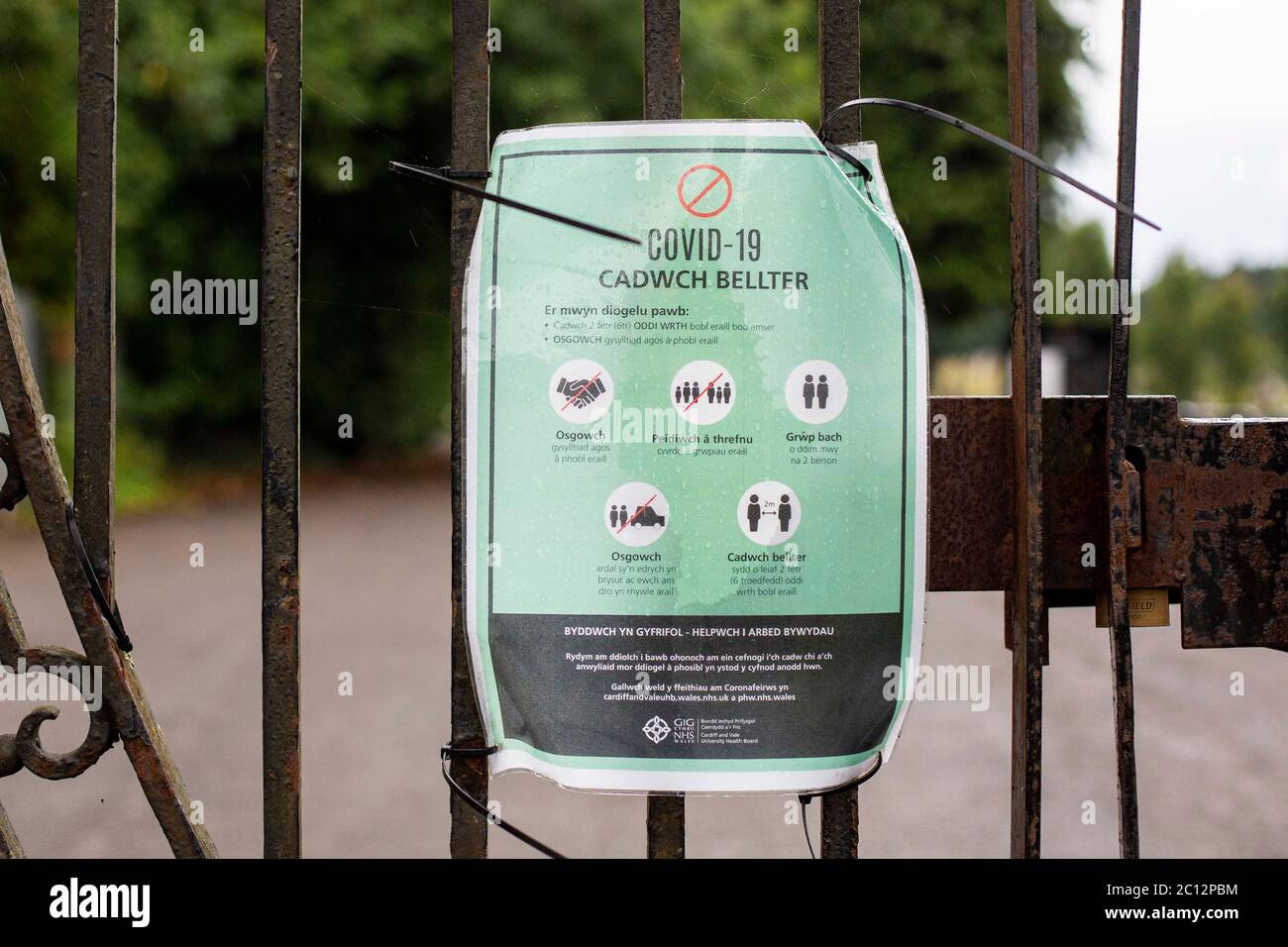 Welsh Language Nhs Wales Covid 19 Social Distancing Signage On A Cemetery Gate In Cardiff June 2020 Stock Photo Alamy