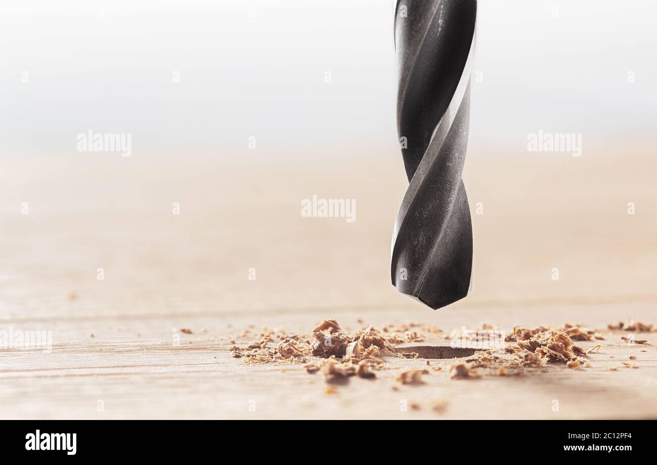 Metal drill bit make holes in clean wooden oak plank. Carpentry work