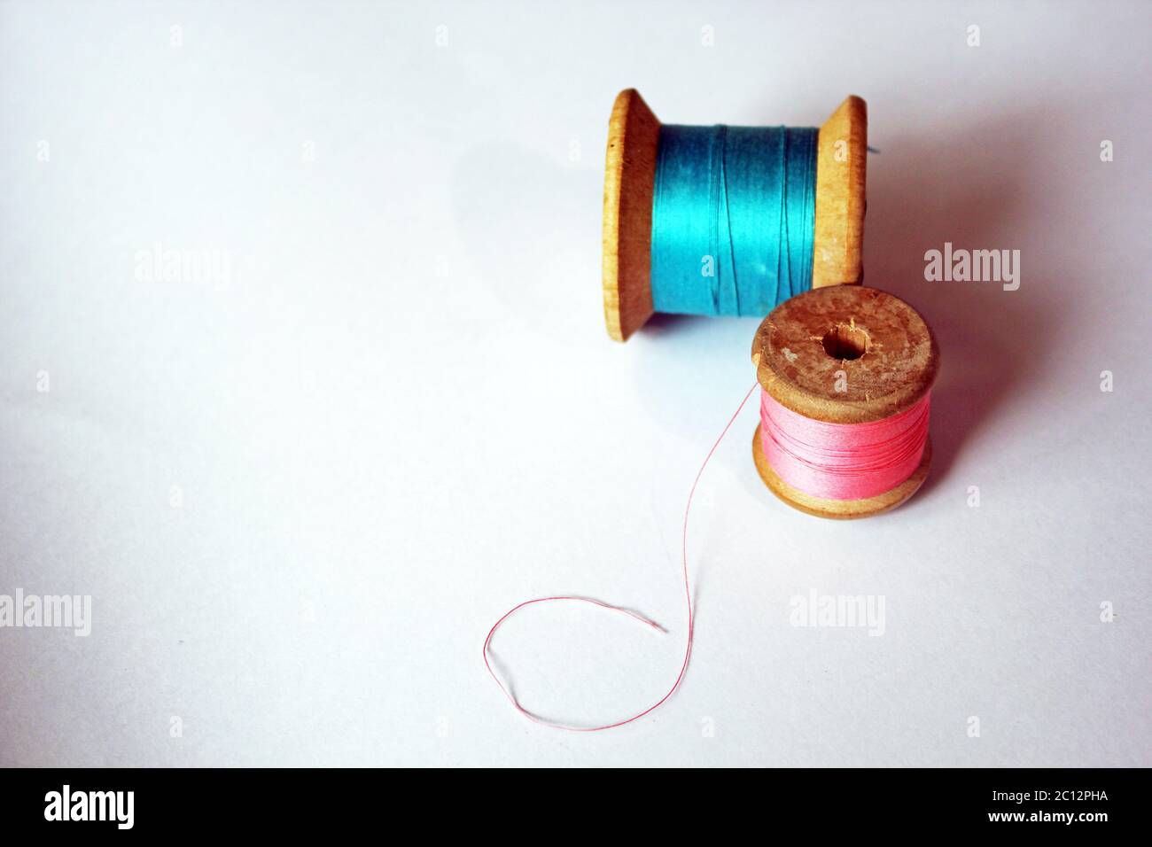 cotton thread reels wooden bobbin pink and blue on bright background with  copy space Stock Photo - Alamy