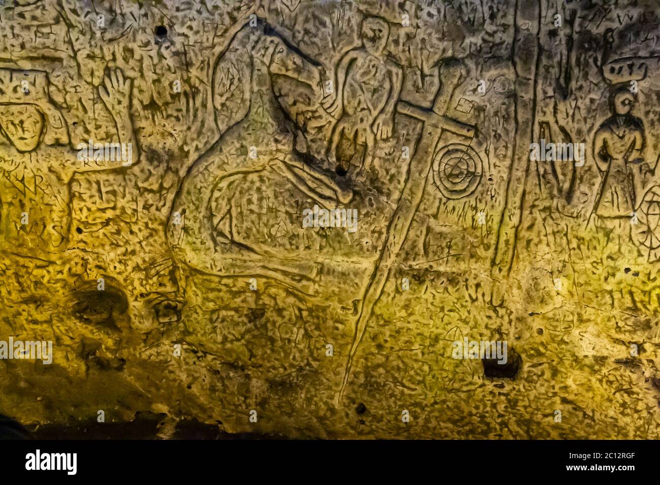 Royston Cave in Herfordshire U.K. still puzzles historians today. The figure on the far left of the picture with the raised arms could be King David from the Book of Psalms. The left arm that is bent to form a square could as well be a sign similar to the Fellow Craft degree of masonry. Royston Cave in Katherine's Yard, Melbourn Street, Royston, England Stock Photo