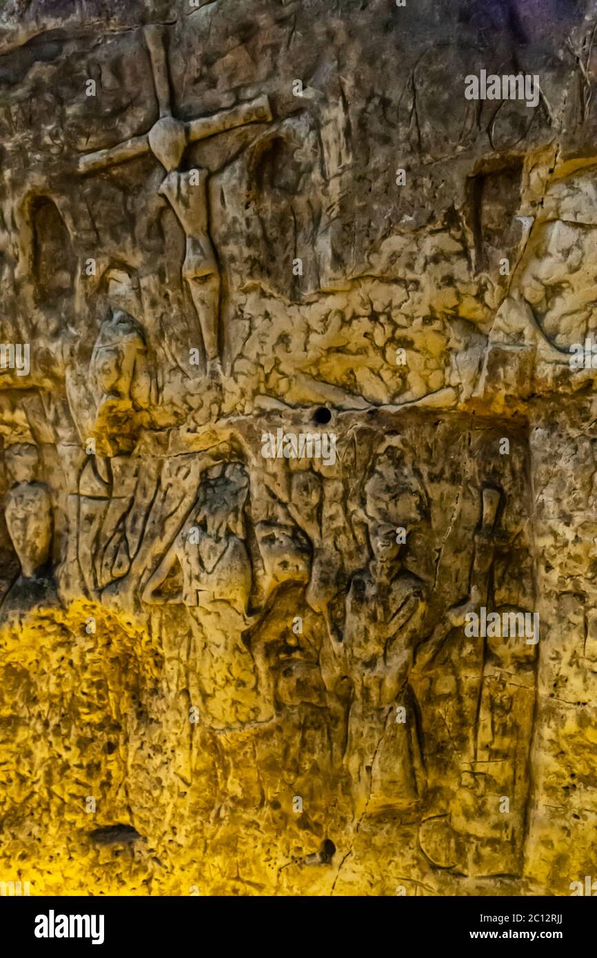 Royston Cave in Herfordshire U.K. still puzzles historians today. The cave is decorated with a large number of low-relief wall sculptures. They are mainly Christian motifs in the medieval style. At the top left is depicted a crucifixion scene. Royston Cave in Katherine's Yard, Melbourn Street, Royston, England Stock Photo