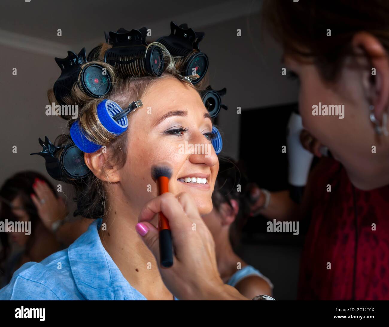 Bride with curlers doing make up. British Wedding in South Cambridgeshire, England Stock Photo