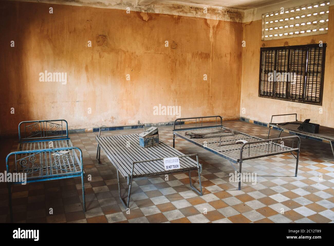 Room with beds in S21 Tuol Sleng Genocide Museum Phnom Penh Cambodia Stock Photo