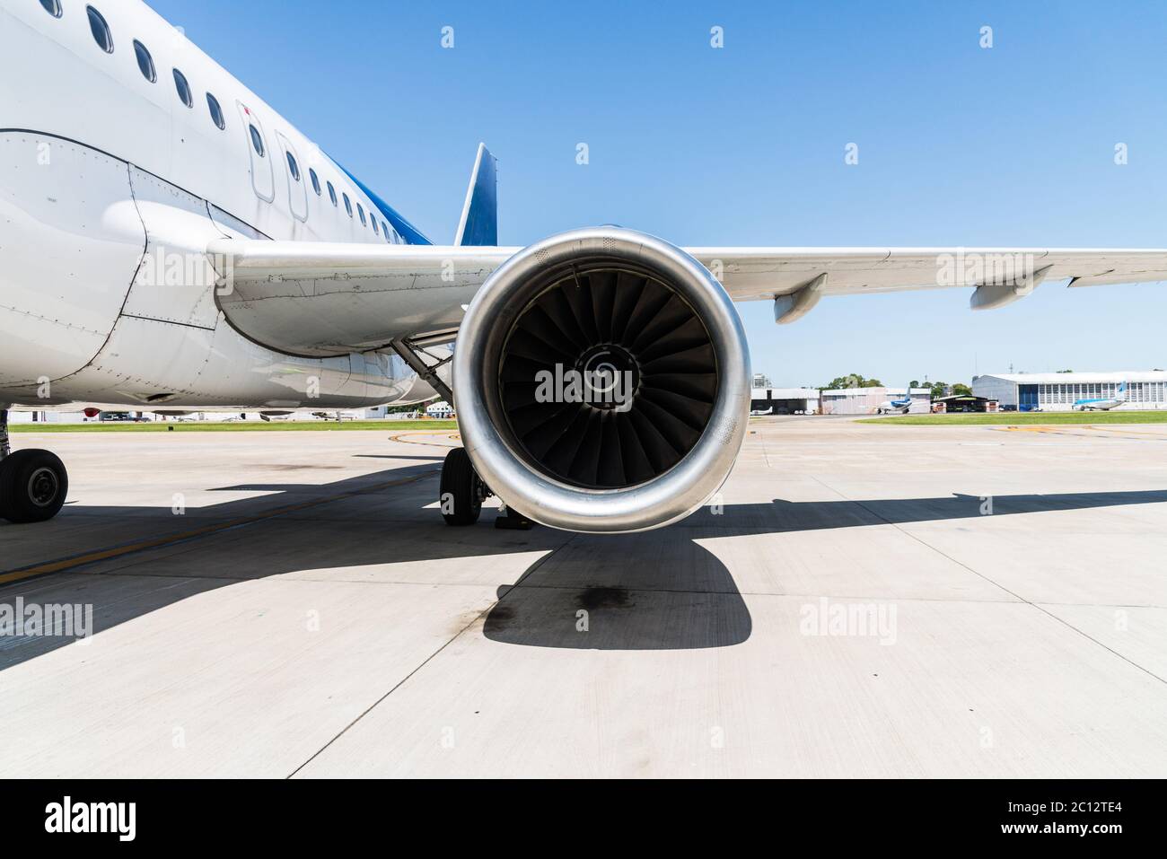 Engine and a wing of an aircraft plane at the airport. Stock Photo