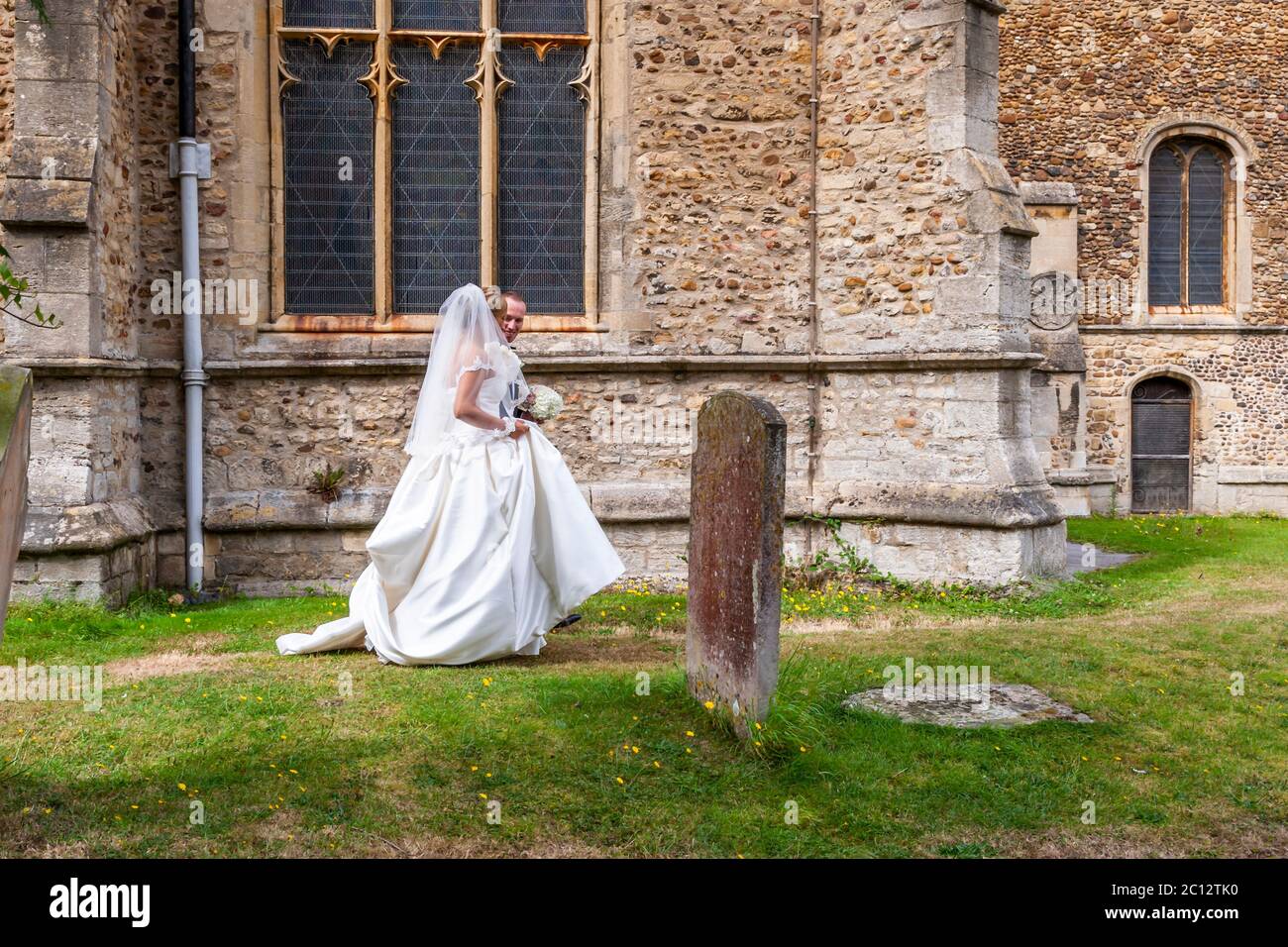 Bride and groom alone in the cemetery. British Wedding in South Cambridgeshire, England Stock Photo