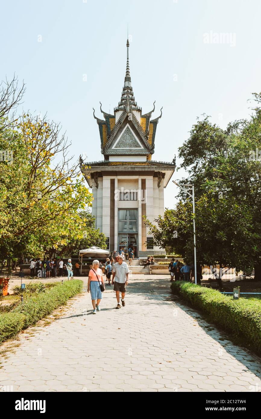 Tourists walking from the memorial tower in the Cambodia Killing Fields Choeung Ek Genocidal Center Phnom Penh Stock Photo
