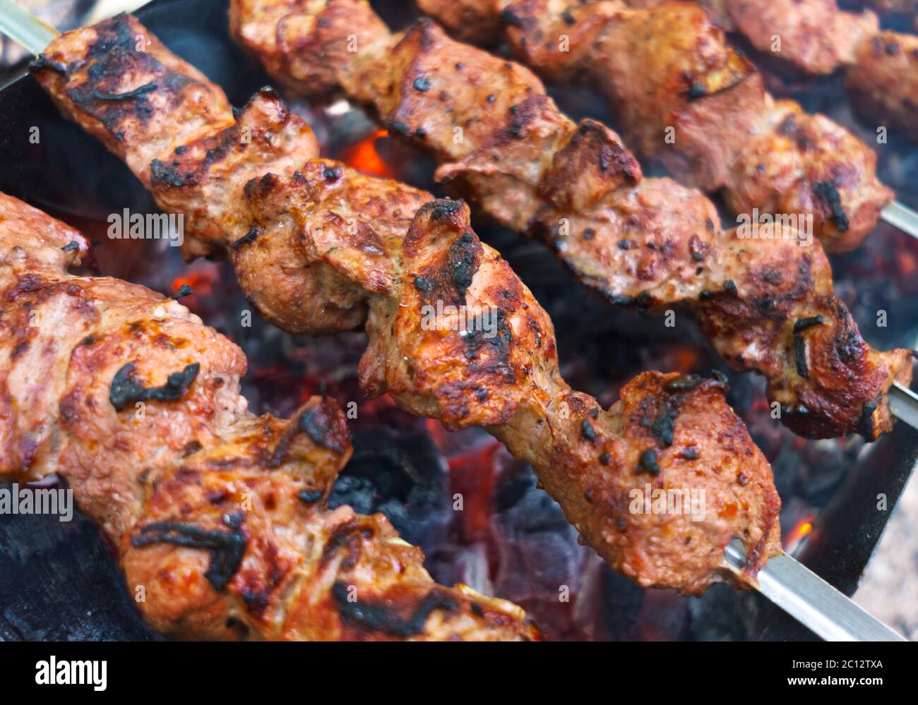 Grilling marinated meat on a grill Stock Photo