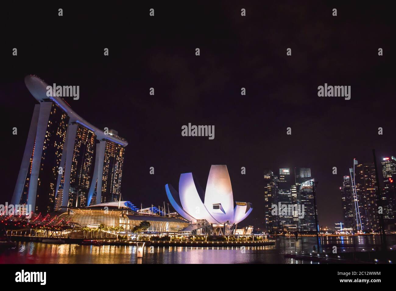 Singapore skyline with the ArtScience Museum and Marina Bay Sands Hotel with night lights reflected in the water of the bay Stock Photo