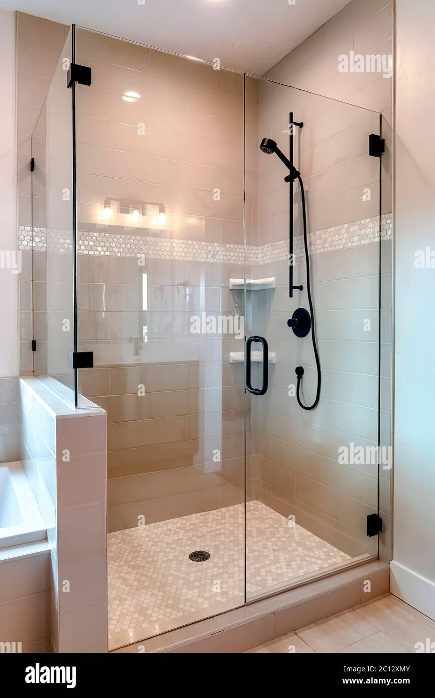 Shower stall with half glass enclosure and black shower head and handle Stock Photo