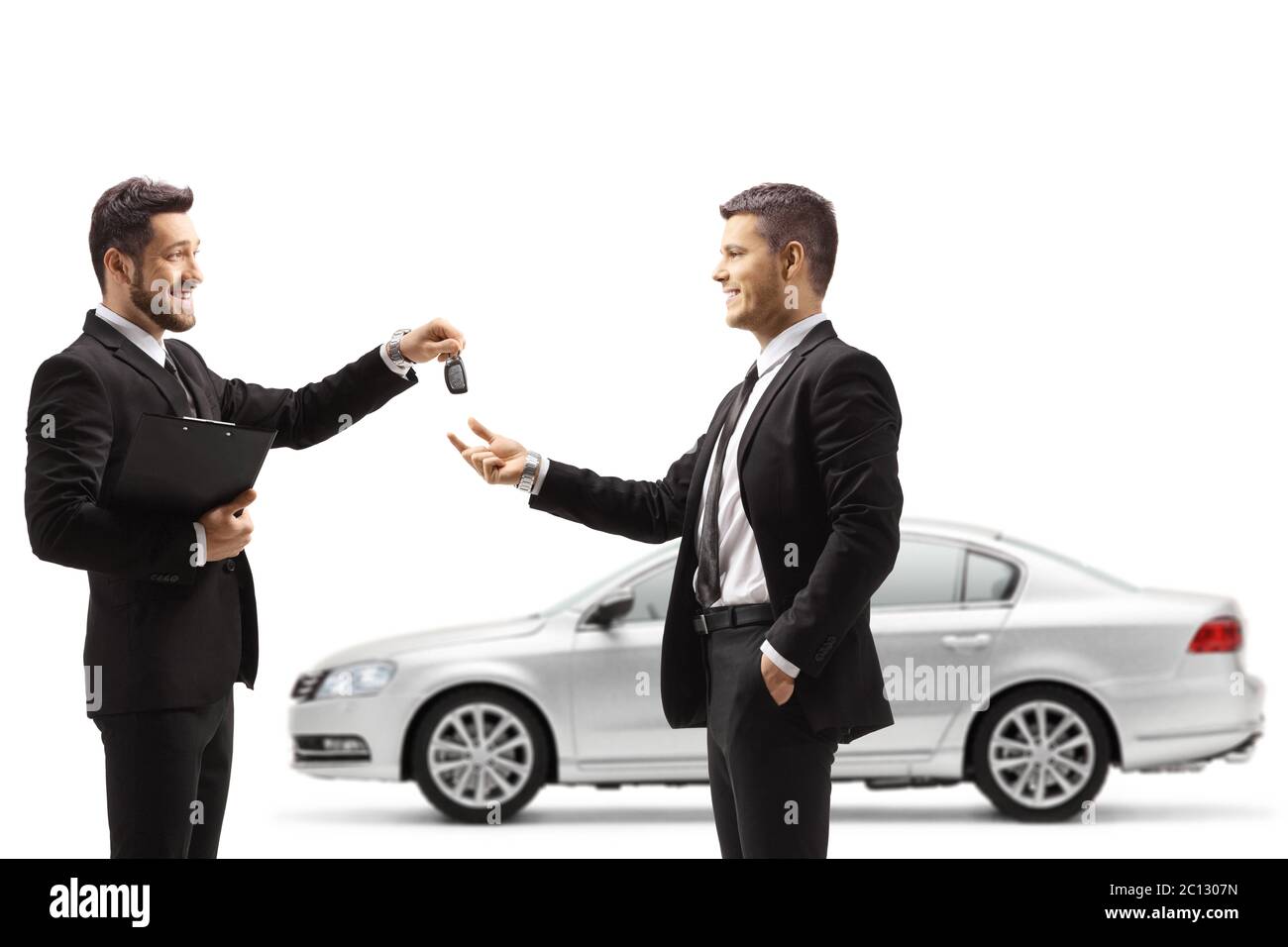Auto dealer giving car keys from a silver car to a businessman isolated on white background Stock Photo