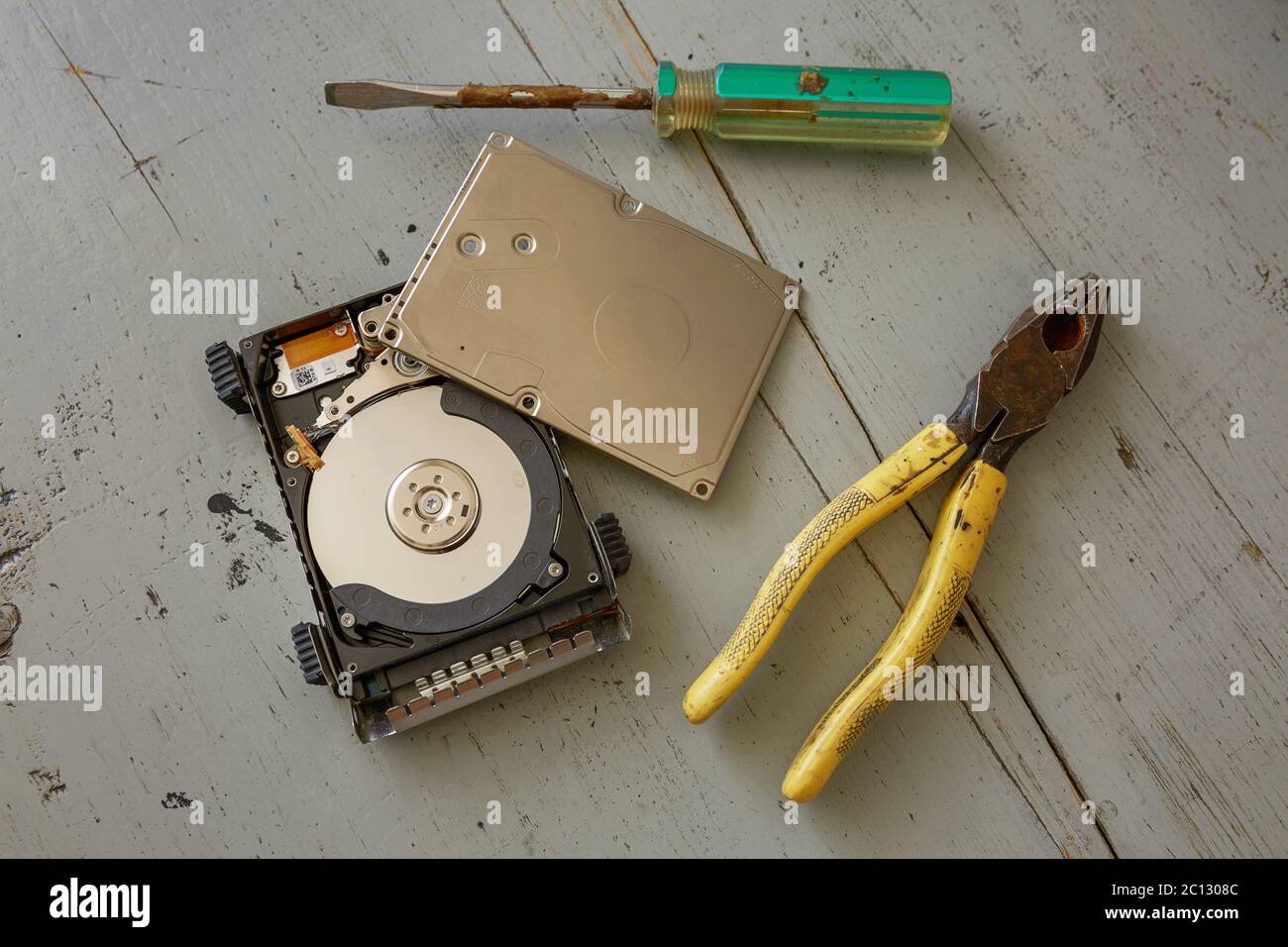 Broken and Destroyed Hard Drive Disk and Tools on Wooden Table Stock Photo
